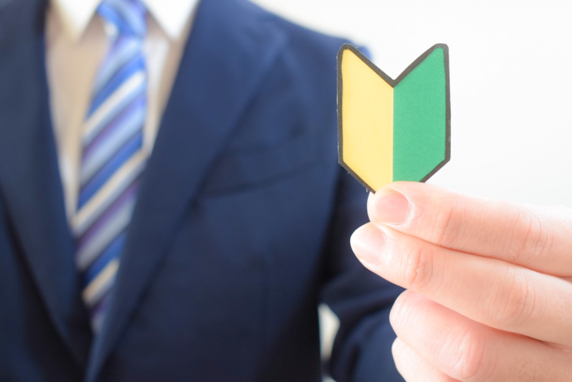 初心者マークを持つスーツの男性